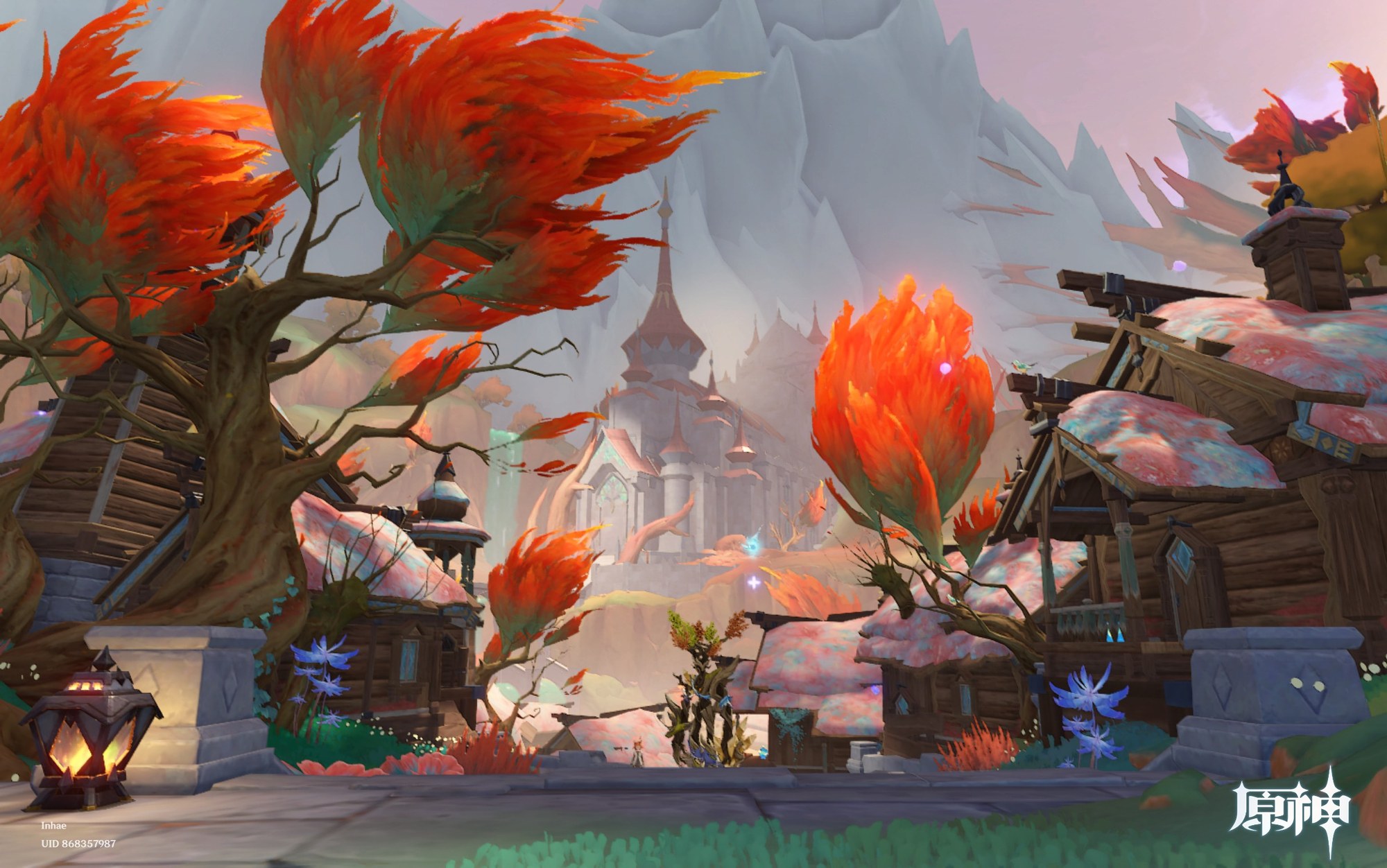 A picturesque village with vibrant autumn-colored trees and rustic buildings sits in the foreground with a grand stone palace visible in the misty mountains beyond.